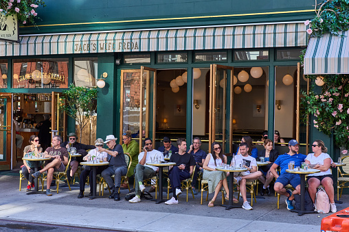 New York, NY - June 29, 2022: Diners sitting at a sidewalk cafe on Lafayette St in Nolita NYC. It is called Jack's Wife Freda Restaurant.