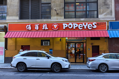New York, NY - June 29, 2022: Popeye's Fried Chicken in Chinatown, NYC where the name is written in both Chinese and English characters.