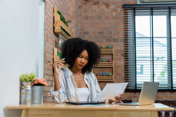 istock Business woman using digital table and working on laptop computer in modern home office. 1409533980