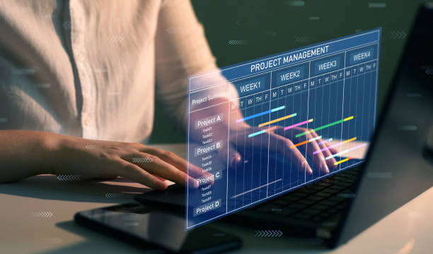istock Business Project Management System. Project manager working on laptop and updating tasks and milestones progress planning with Gantt chart scheduling interface for company on virtual screen. 1409535387