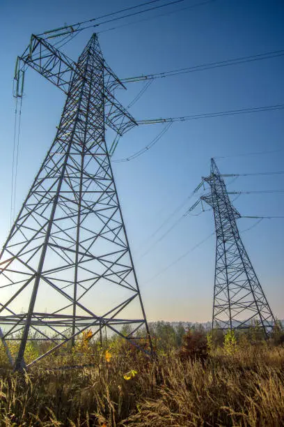 Photo of Two high voltage power lines against the background of the blue sky.