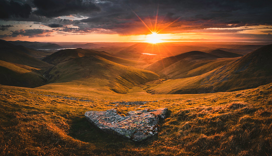 A panoramic sunset from Great Sca Fell in the Lake District looking towards the Solway Firth and Uldale Fells including Meal Fell, Great Cockup and Longlands Fell.