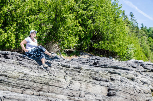 istock Mature woman sitting on rock formation 1409539111