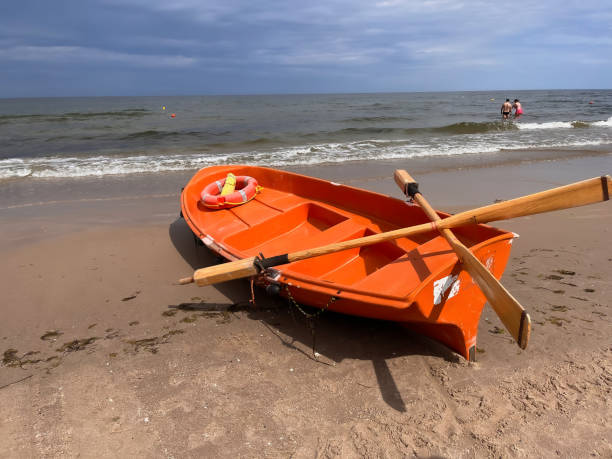 kleines rettungsboot am strand - lifeguard orange nature beach stock-fotos und bilder