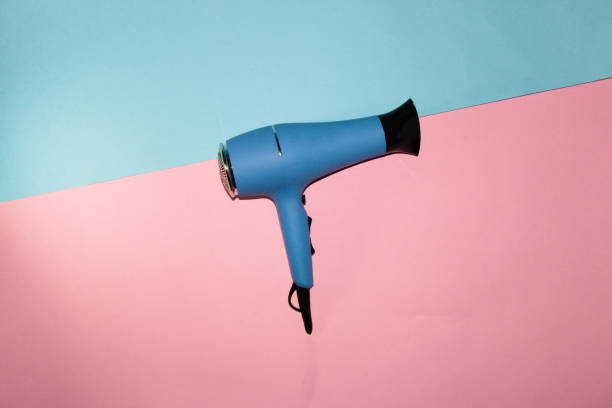 asciugacapelli blu isolato su sfondo blu rosa, arte creativa design moderno - hair dryer single object plastic black foto e immagini stock