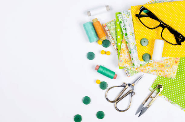 istock Accessories for sewing and needlework. Fabric, spools of thread, scissors and glasses. 1409542528