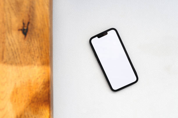 istock Smartphone with mockup white screen on modern sofa arm, top view 1409544788