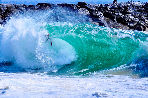 Surfer hopelessly stuck in the lip of a crashing, green wave  at the Wedge
