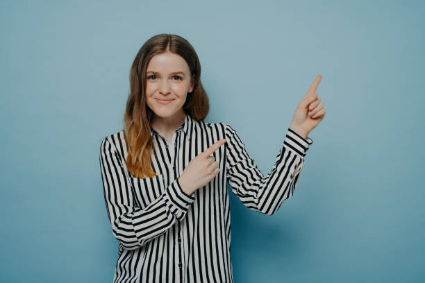 istock Studio shot of happy female pointing up at copy space 1409549163