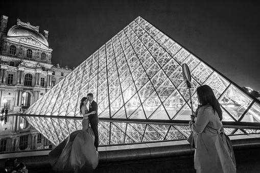 05-07-2016 Paris, France,.  Chinese tourists (bride and groom) like to arrange a spectacular photo shoot in the Louvre near the Pyramid