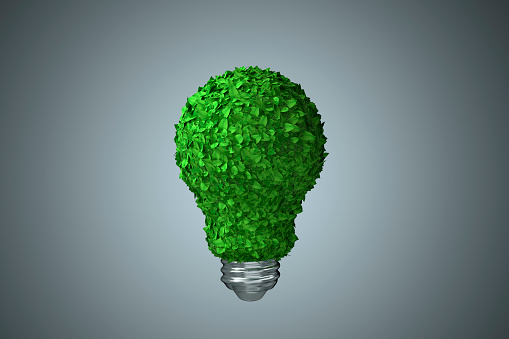 Lamp made of green leaves on grey background as a symbol of recycle and green energy