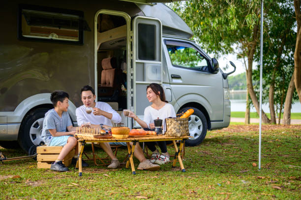 istock Happy Asian parents and their kid communicating while spending a spring day on camping. - Camper van travel series 1409551267