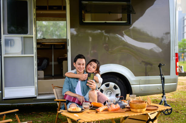 istock Happy Asian couple taken selfie while spending a spring day on camping 1409551336
