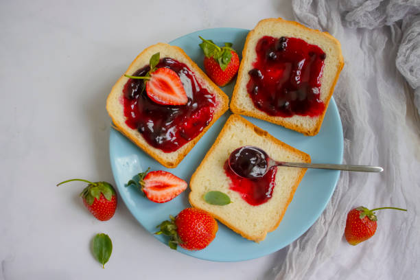 istock Bread, fresh strawberry, jam on wooden background 1409553471