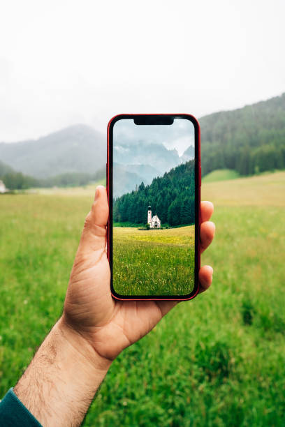 pov-ansicht eines mannes, der die kirche st. johannes von nepomuk in ranui mit seinem smartphone fotografiert - saint johann stock-fotos und bilder