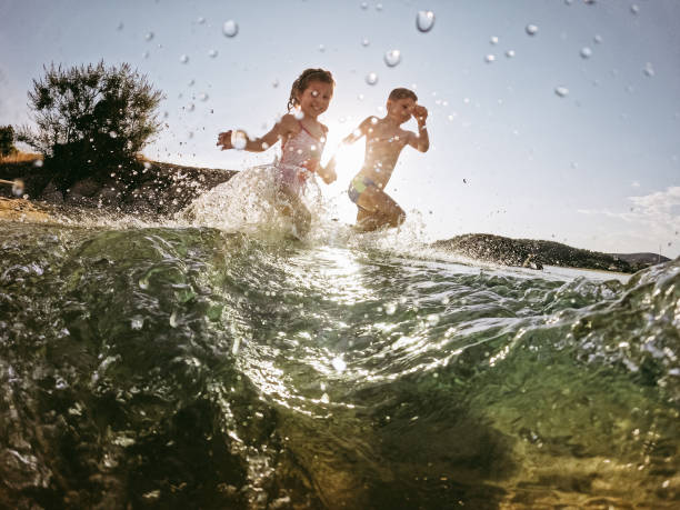 istock Kids playing in the sea 1409558051