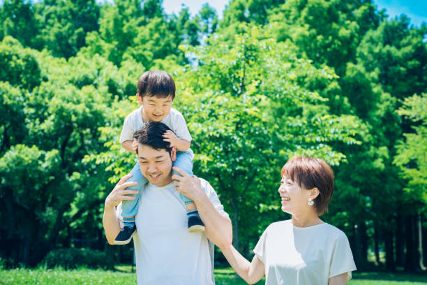istock Parents and child playing while piggybacking in the park 1409560031