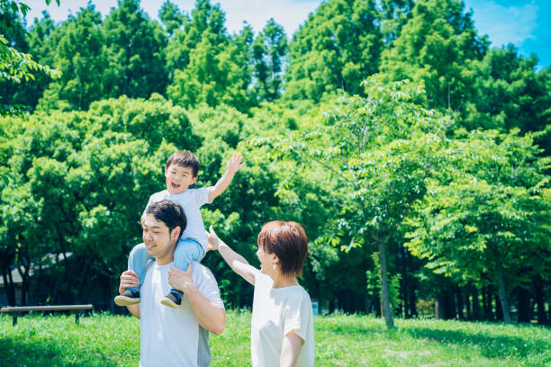 istock Parents and child playing while piggybacking in the park 1409560126