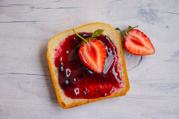 istock Bread, fresh strawberry, jam on wooden background 1409561105