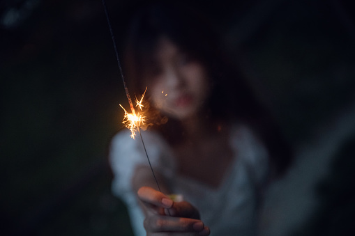 Asian girls playing fireworks at night