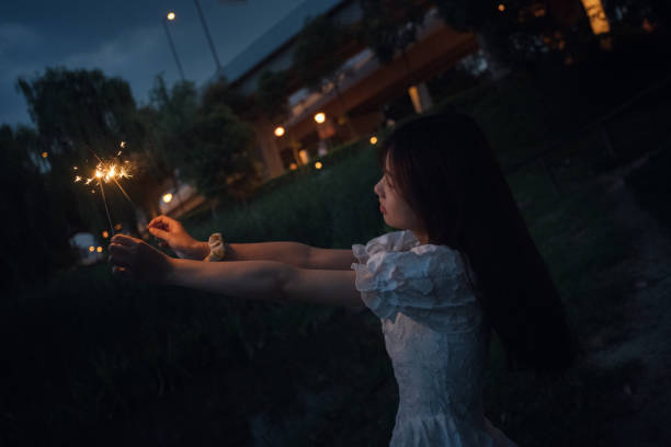 istock Asian girls playing fireworks at night 1409563419