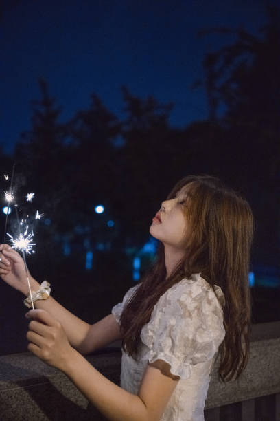 istock Asian girls playing fireworks at night 1409563455
