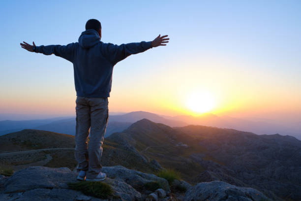 istock Man meets the dawn with open arms 1409563553