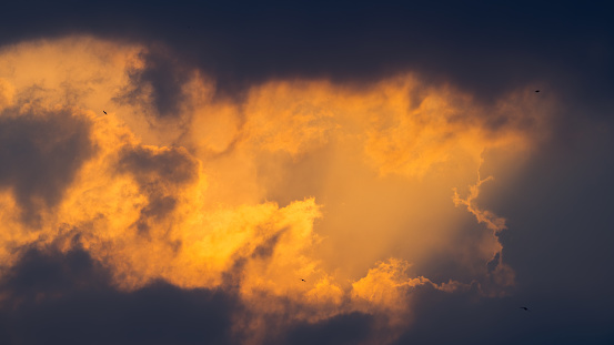 cloudy sky in dramatic orange sunlight during the sunset period. Nature, background and texture photo.