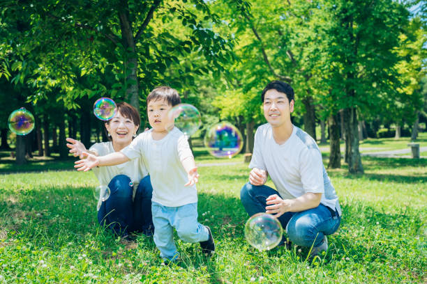 Parents and their child playing with soap bubbles at the park