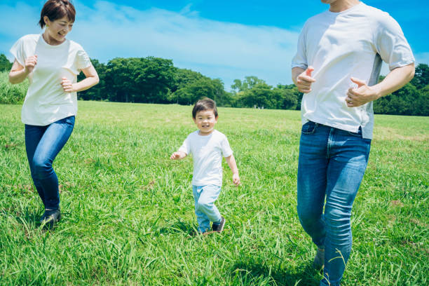 istock Parents and their child running around the meadow 1409564820