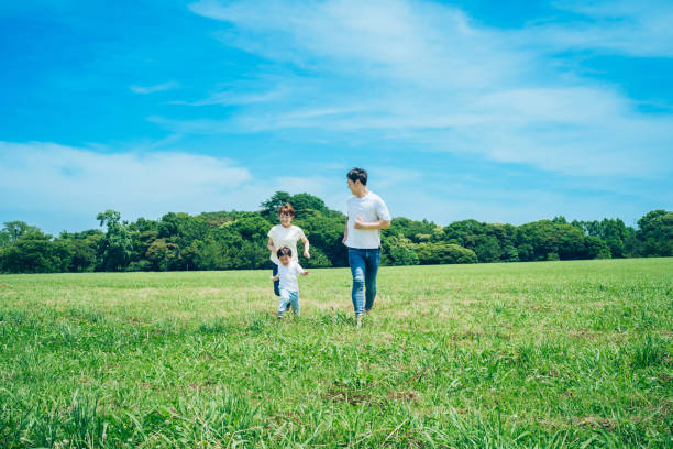 Parents and their child running around the meadow