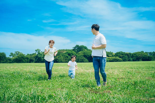 istock Parents and their child running around the meadow 1409565279