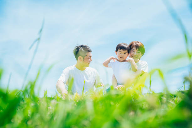 istock Parents and their child sitting on a sunny green space 1409566021