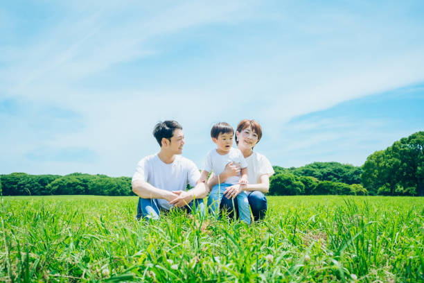 istock Parents and their child sitting on a sunny green space 1409566062