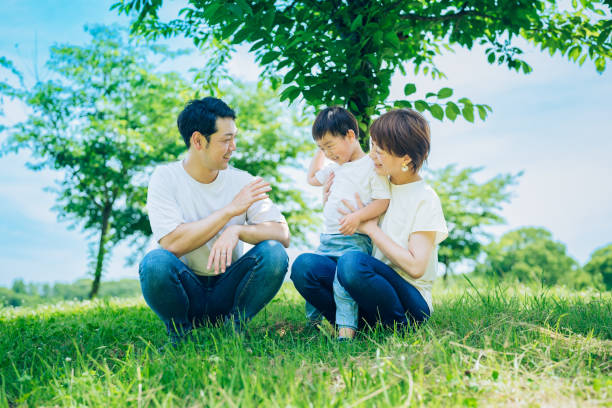 istock Parents and their child sitting on a sunny green space 1409566113