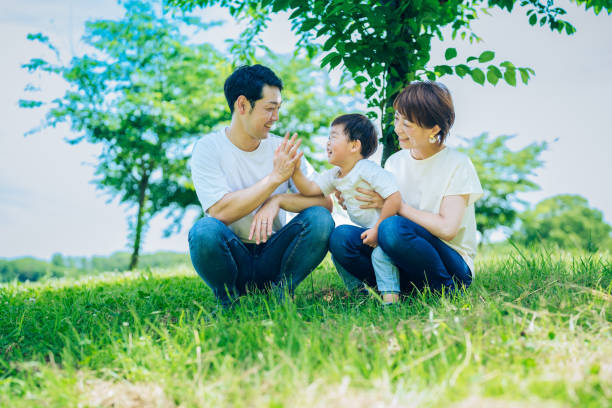 istock Parents and their child sitting on a sunny green space 1409566202