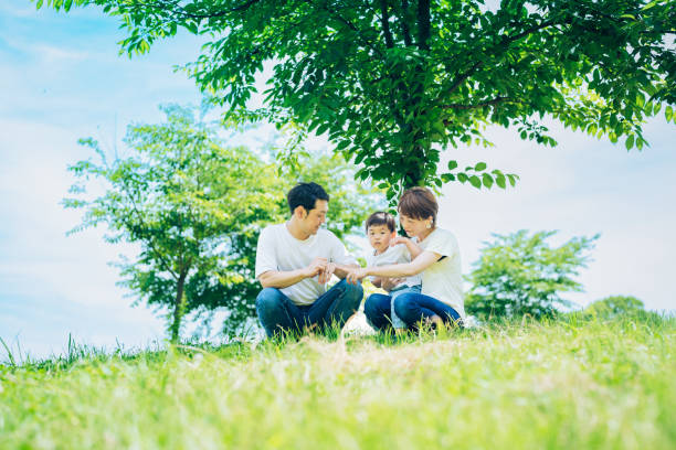 istock Parents and their child sitting on a sunny green space 1409566370