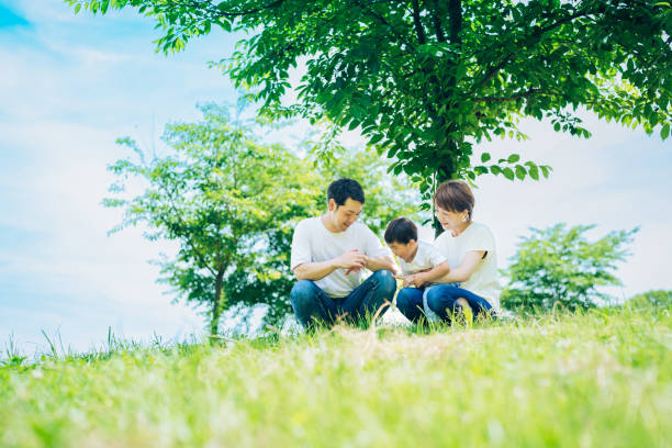 istock Parents and their child sitting on a sunny green space 1409566400