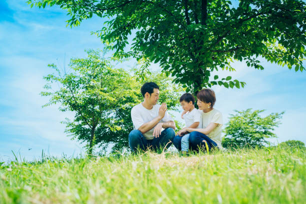 istock Parents and their child sitting on a sunny green space 1409566449