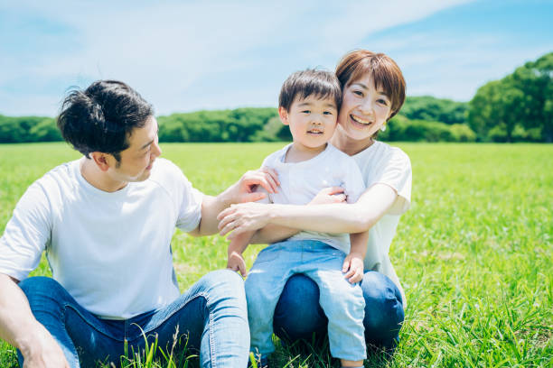 istock Parents and their child sitting on a sunny green space 1409566530