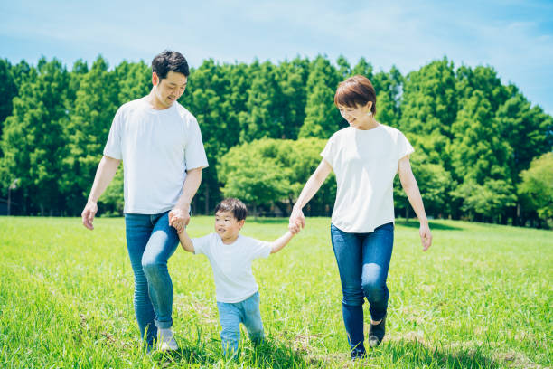 istock Parents and their child walking on a sunny green space 1409566587
