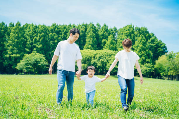 istock Parents and their child walking on a sunny green space 1409566613