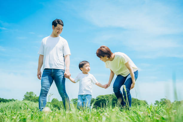 istock Parents and their child walking on a sunny green space 1409566633