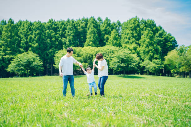 istock Parents and their child walking on a sunny green space 1409566669