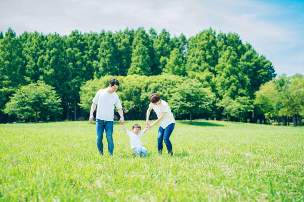 istock Parents and their child walking on a sunny green space 1409566699