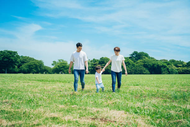 istock Parents and their child walking on a sunny green space 1409566723