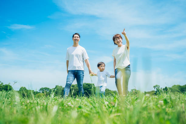 日当たりの良い緑地を歩く親子 - two generation family 写真 ストックフォトと画像