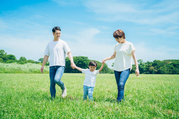 istock Parents and their child walking on a sunny green space 1409567301