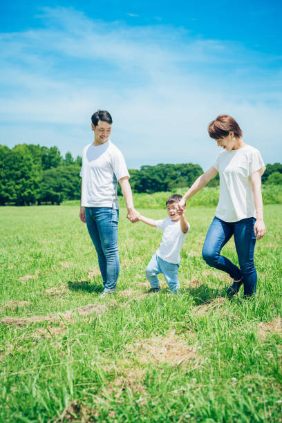 istock Parents and their child walking on a sunny green space 1409567361