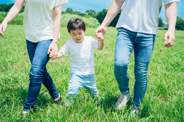 istock Parents and their child walking on a sunny green space 1409567448